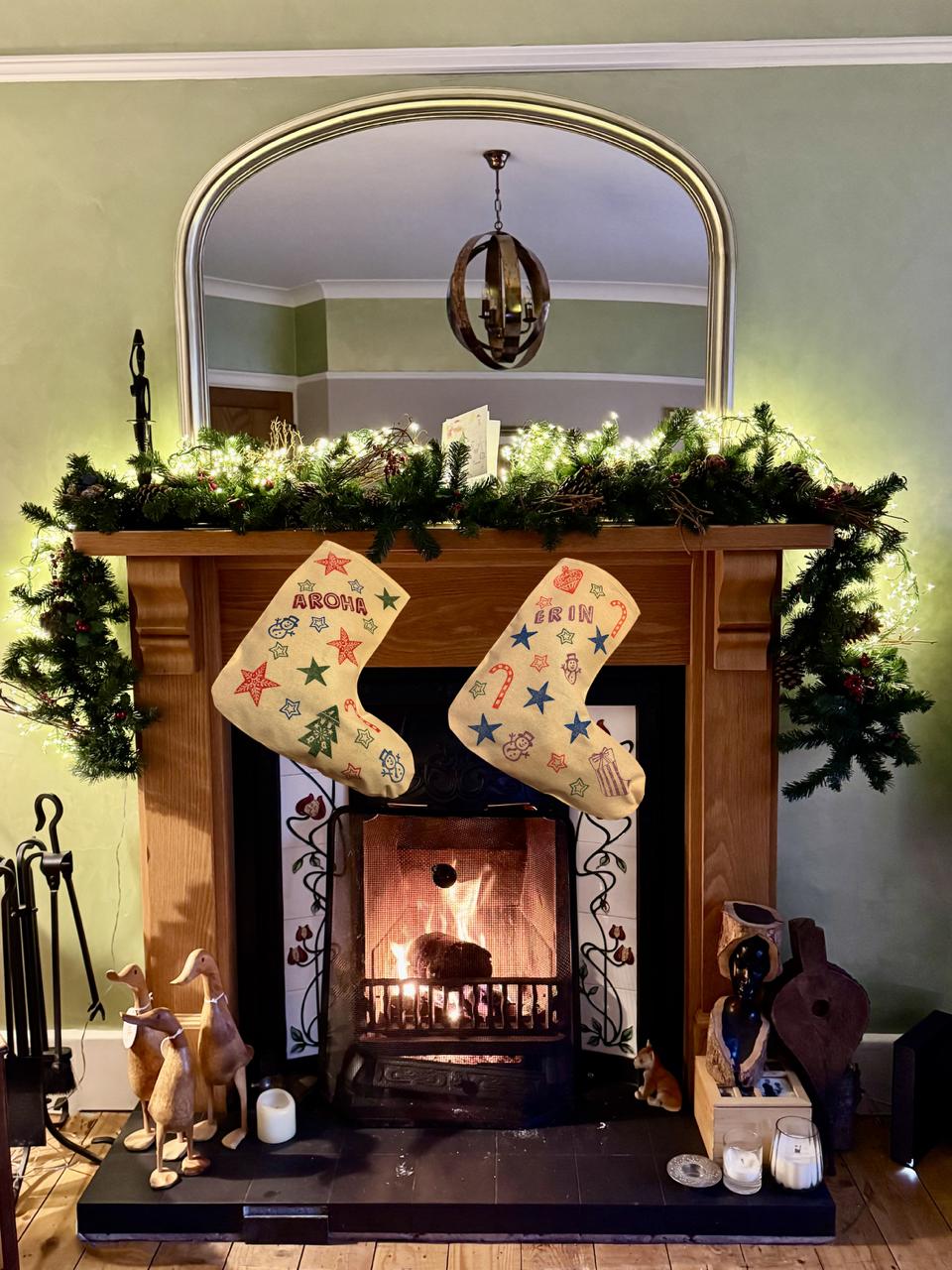 Decorated fireplace with stockings, wreath, and festive decor.