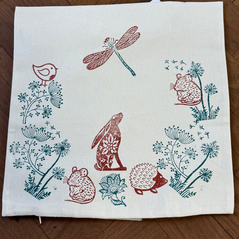 Cotton fabric cushion cover with hand block printed wooden animals and plants in earthy tones